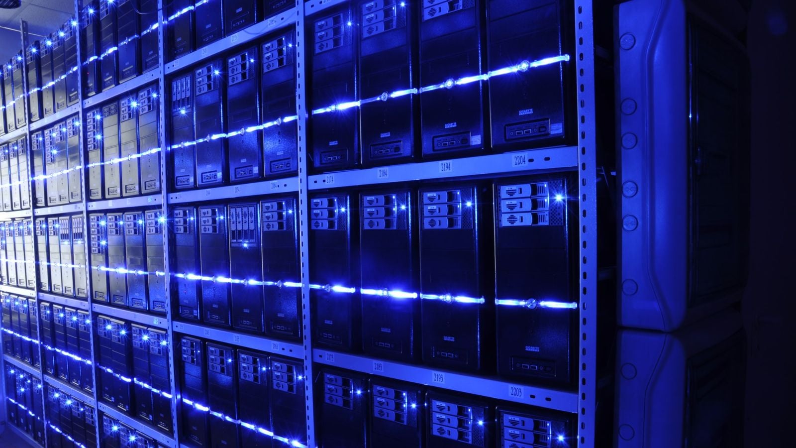 サーバールームで青いLEDストリップに照らされた金属棚に並ぶタワー型コンピューターケース。写真はYandexの施設を写したものではない